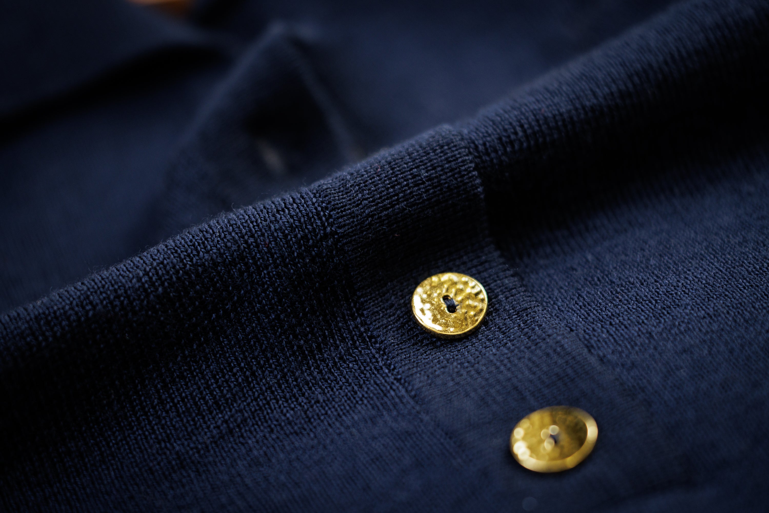Close-up of a navy garment with gold buttons