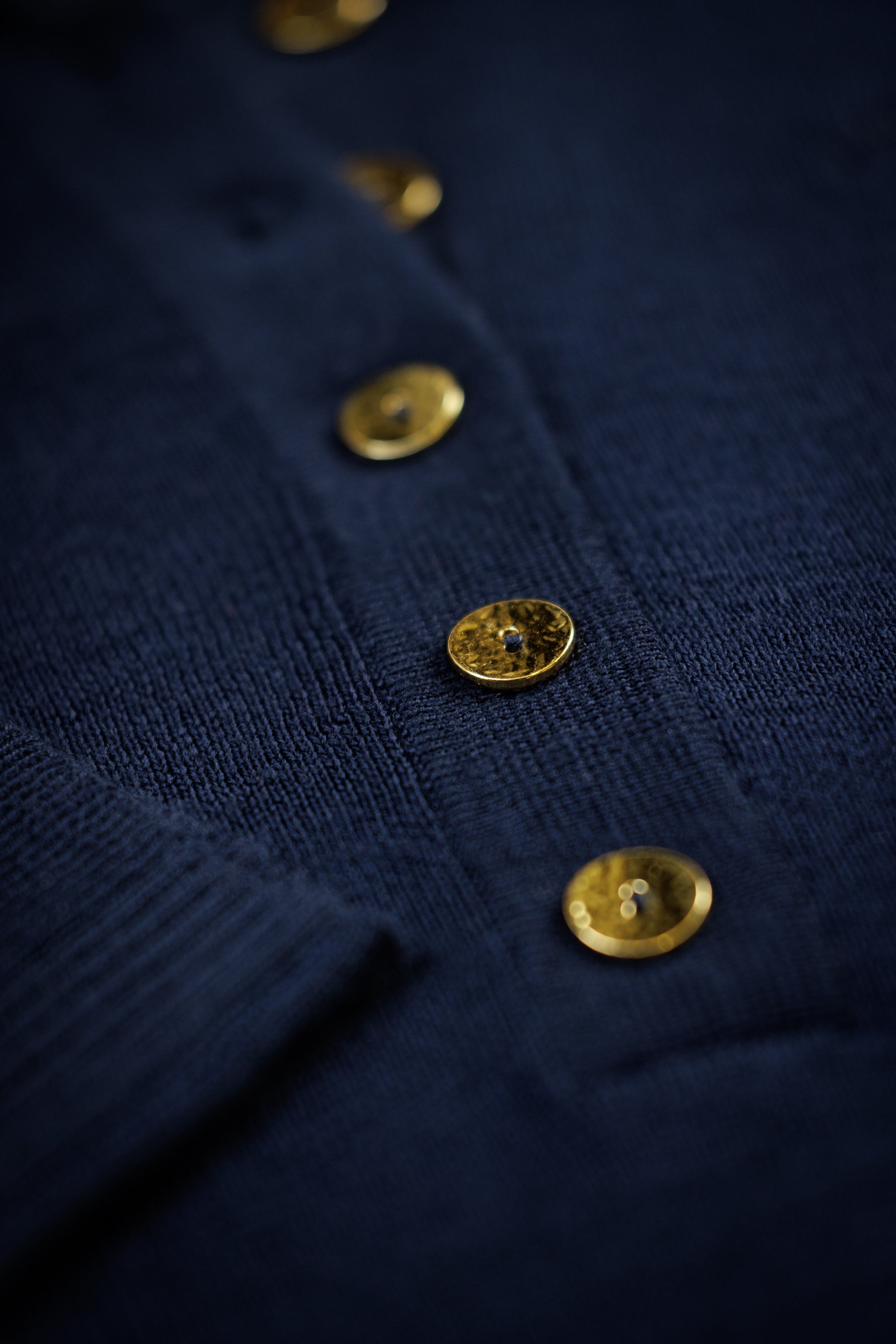 Close-up of a navy garment with gold buttons