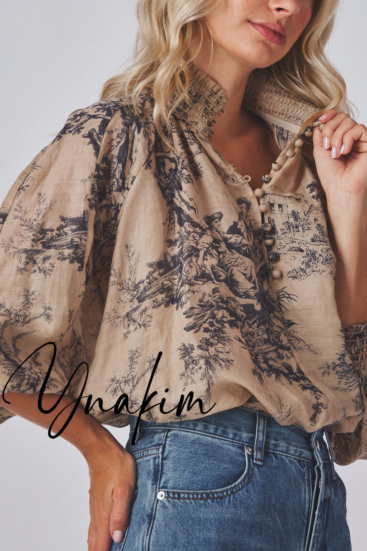 Model wearing a print blouse and jeans with 'Ynakim' branding.