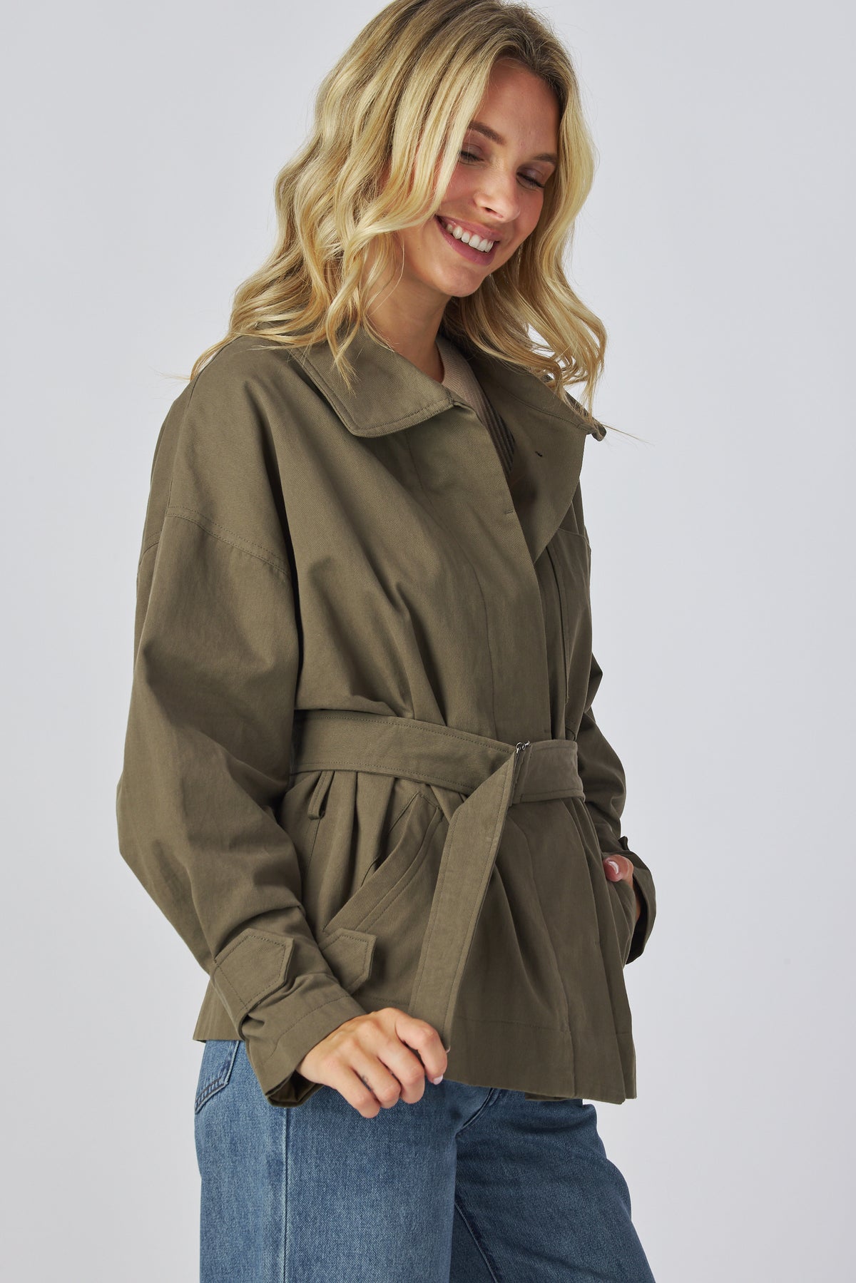 Linden Jacket in olive showing the strap cuffs and side pockets, three quarter view