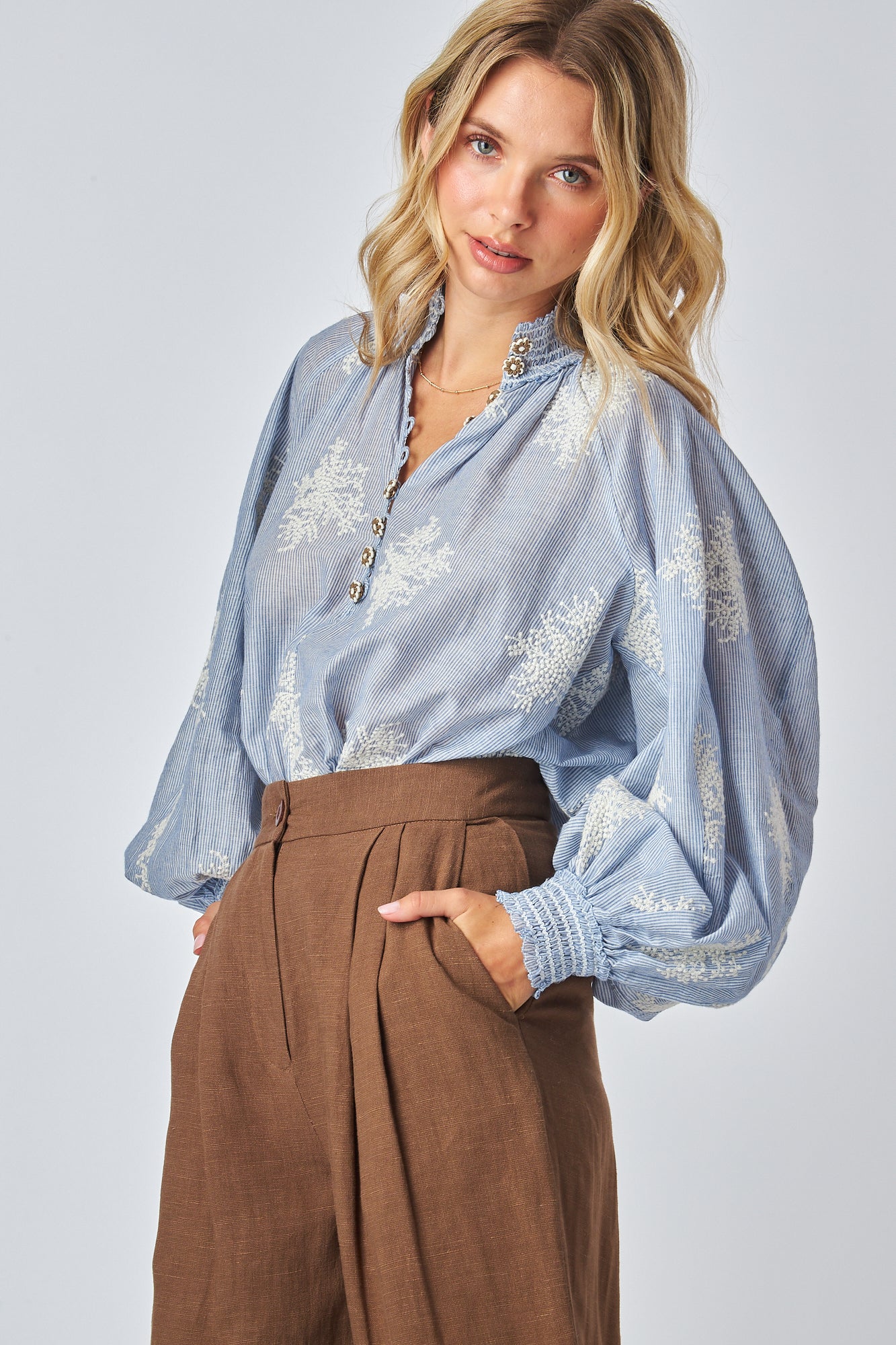 Victorina Style Blouse 
Elastic shirred collar
Button up detail
Puff sleeves with fitted cuffs
Embroidered floral accents in natural color
Loose fit blouse