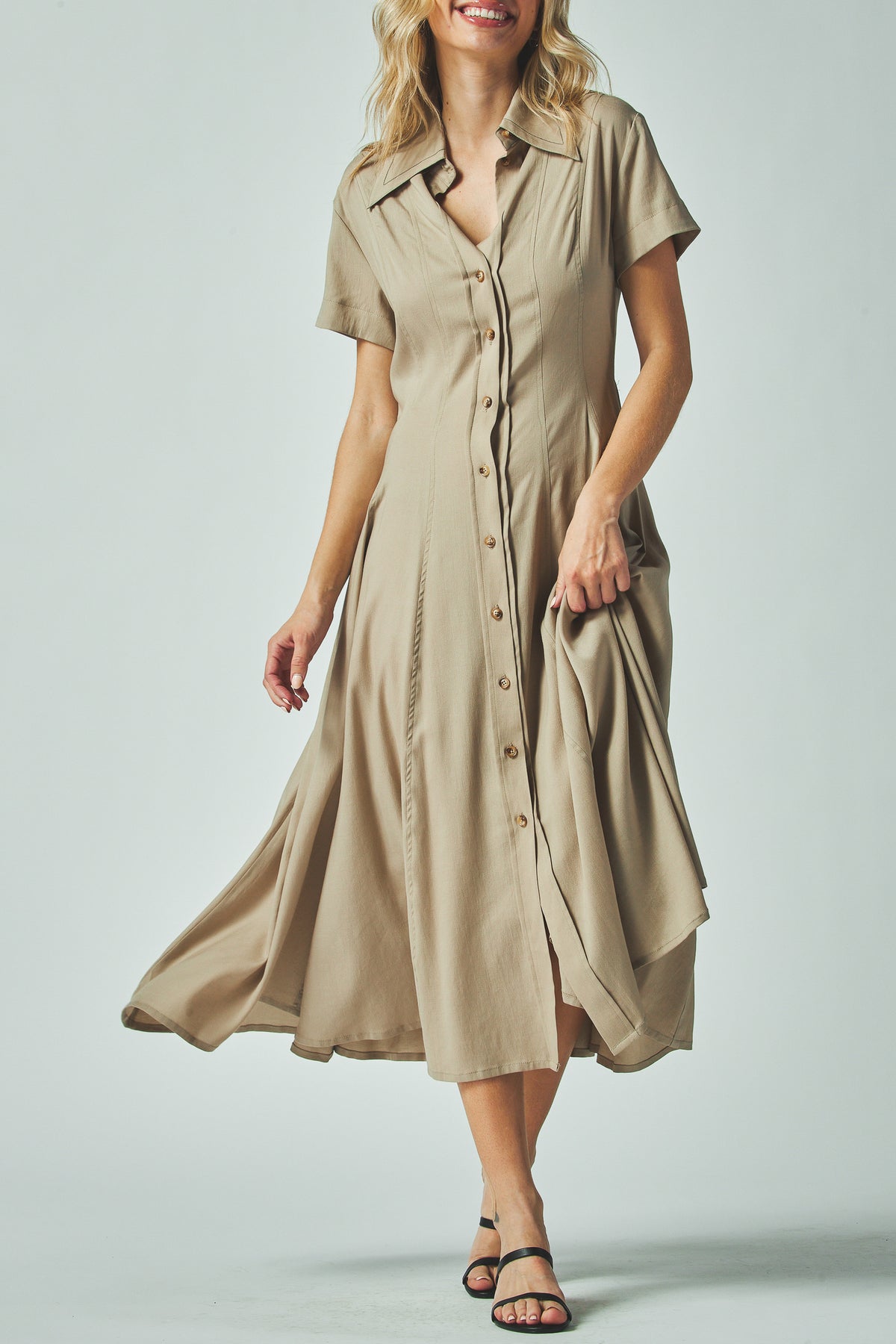 Nora Dress in taupe with an open shirt collar, front view of the flared skirt