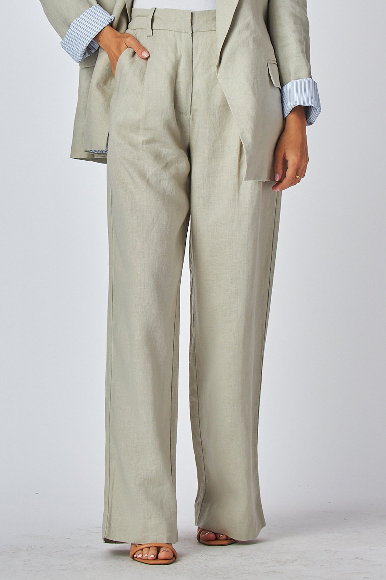Beige suit pants worn by a model posing relax