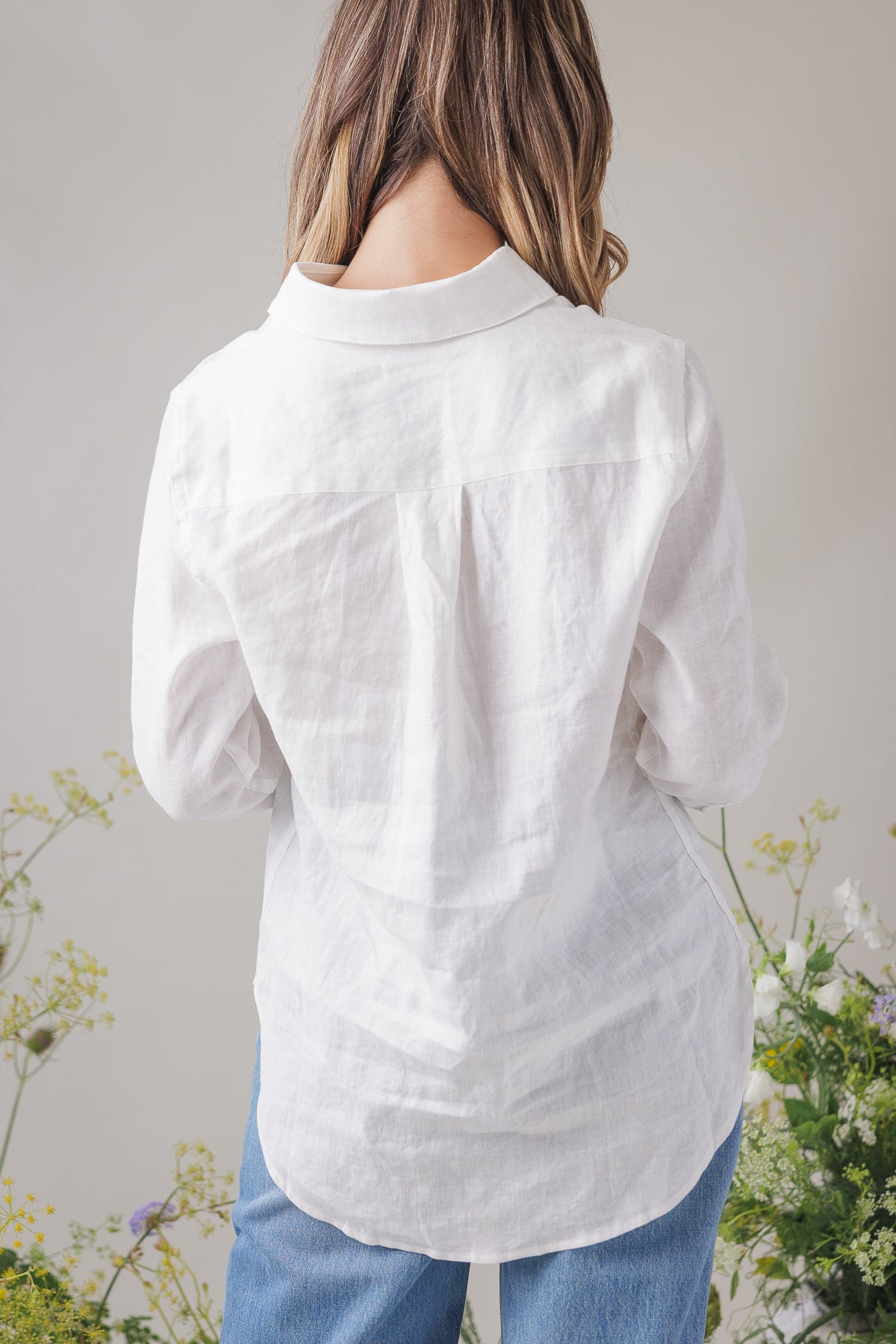 Aries Top white linen shirt back view worn, showing the yoke and curved hem